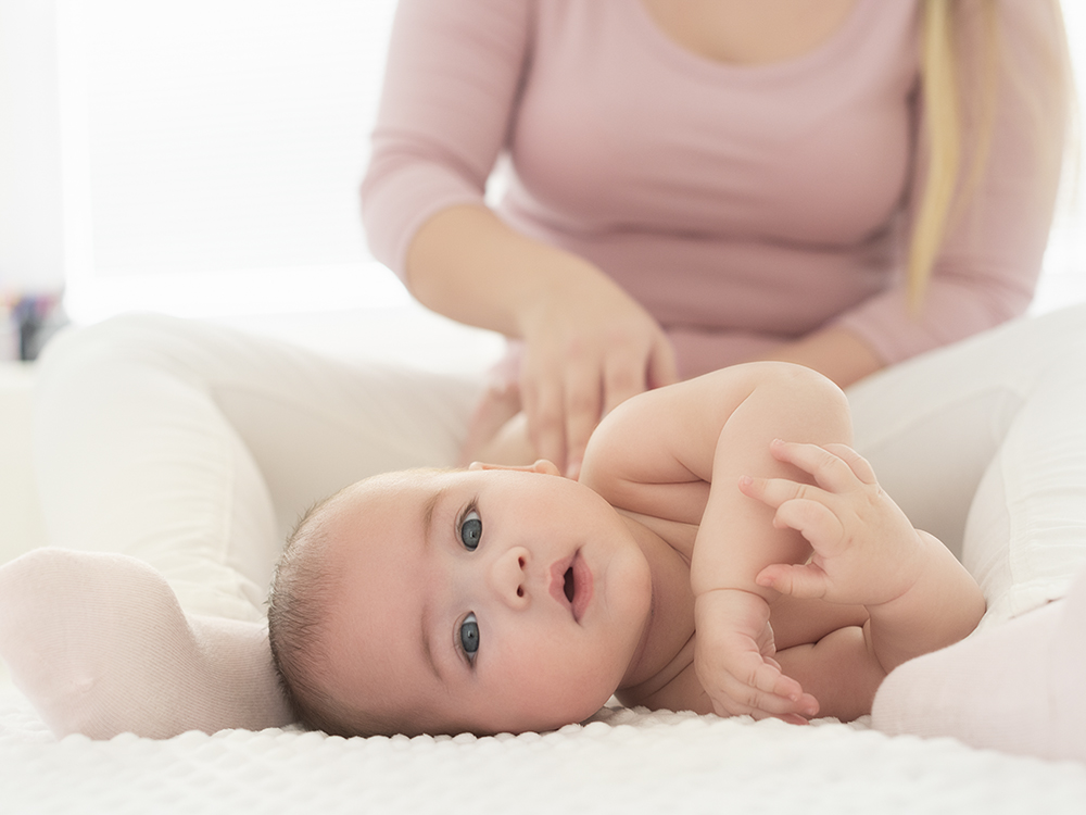 cute baby being massaged with baby oil