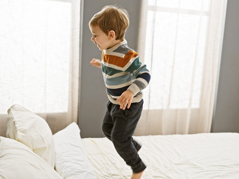 toddler jumping on bed