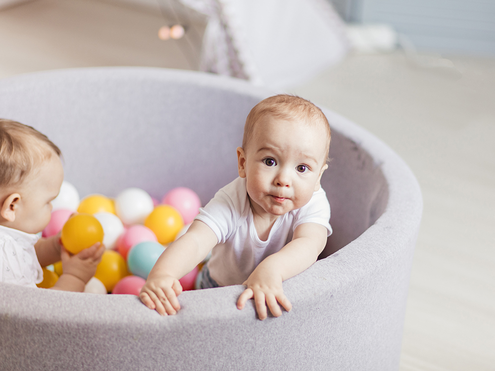 toddler and baby in ball pit