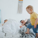 kid trying to wake up sleeping parents