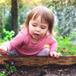 toddler playing in garden outside