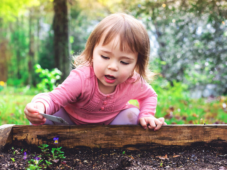 toddler playing in garden outside