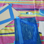 painting over blue tape on top of towel for easy activity