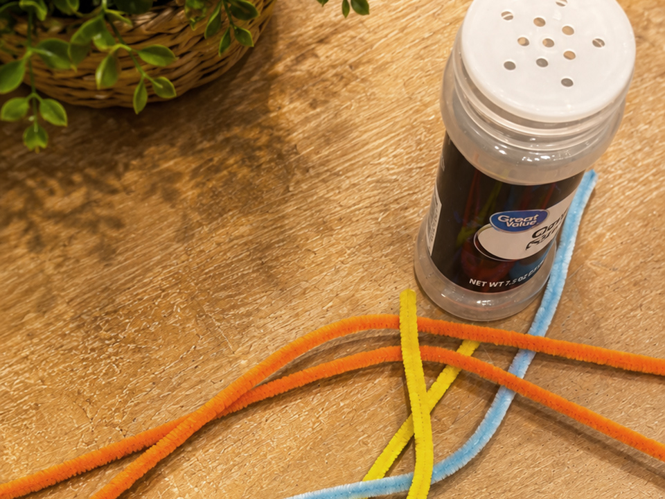 threading pipe cleaners through an old seasoning container