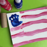 canvas with toddler handprint for stars and white and red stripes to make flag for fourth of july