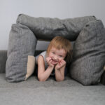 toddler under couch cushions