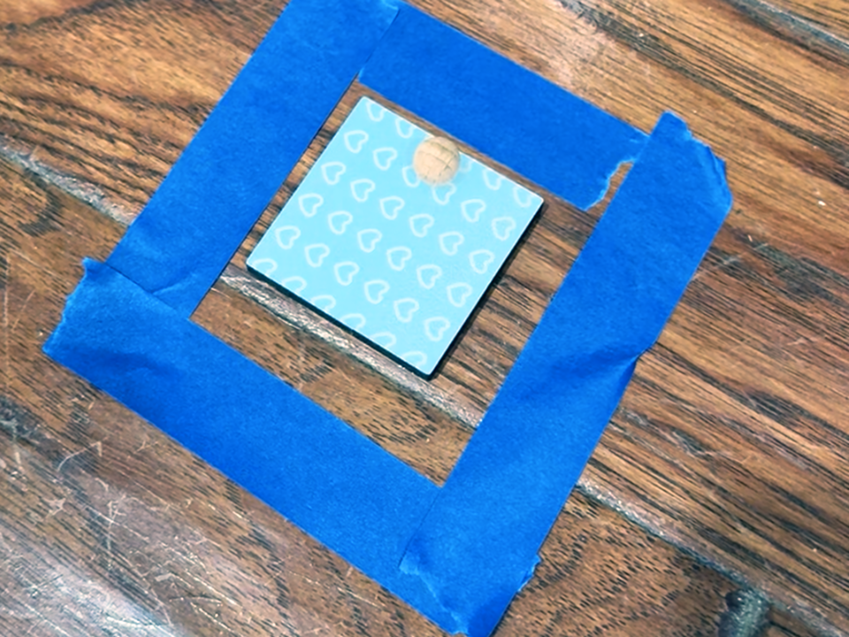 blue square toy in square blue tape shape on floor