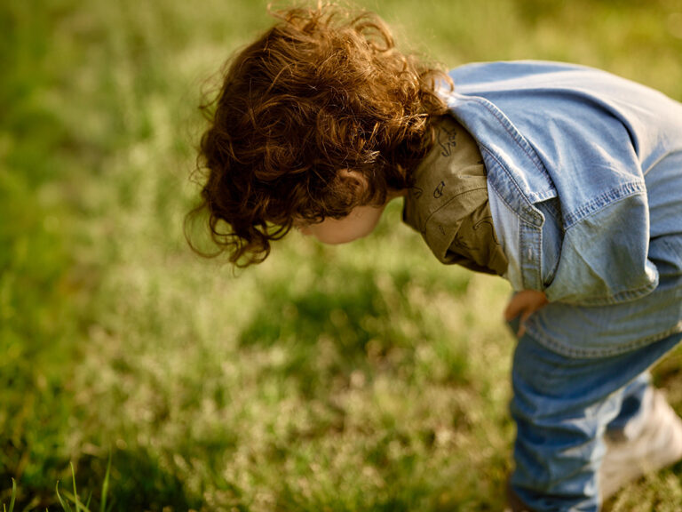 toddler looking at grass